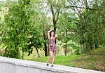 Young Beautiful Smiling Girl Posing While Standing In The Park Stock Photo