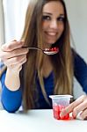 Young Beautiful Woman Eating Yogurt At Home Stock Photo