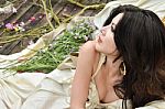 Young Beautiful Woman Lie Down With Flowers Outdoor Stock Photo