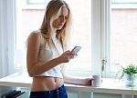 Young Beautiful Woman Using Her Mobile Phone At Home Stock Photo