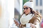Young Beautiful Woman Using Her Mobile Phone In A Cafe Stock Photo