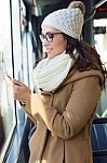 Young Beautiful Woman Using Her Mobile Phone On A  Bus Stock Photo