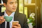 Young Businessmen Are Thinking And Holding A Cup Of Coffee Stock Photo