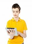 Young Caucasian Kid Working On Tablet Pc Stock Photo