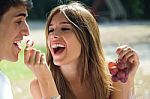 Young Couple Eating Grapes On Romantic Picnic In Countryside Stock Photo