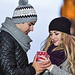Young Couple In Love Embracing And Drinking Hot Drink From Red C Stock Photo