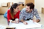 Young Couple Looking At The Blueprints Of Their New Home Stock Photo