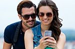 Young Couple Of Tourist In Town Using Mobile Phone Stock Photo