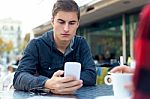 Young Entrepreneur Using His Mobile Phone At Coffee Shop Stock Photo