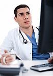 Young Ethnic Doctor Looking Deeply At The Computer Stock Photo