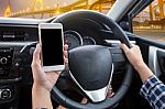 Young Female Driver Using Touch Screen Smartphone And Hand Holdi Stock Photo
