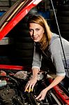 Young Female Trainee Fixing Car Engine In Garage Stock Photo