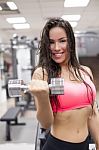 Young Female Working Out With Dumbbells In A Gym Stock Photo