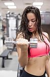 Young Female Working Out With Dumbbells In A Gym Stock Photo