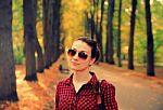 Young Girl In Checkered Shirt In Autumn Park Stock Photo