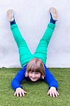 Young Girl Lying Upside Down Against Wall Stock Photo