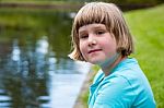 Young Girl Sitting At Pond Stock Photo