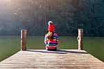 Young Girl Sitting On A Pier Stock Photo