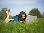 Young Girl Using Laptop In Park Stock Photo