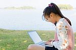 Young Girl With Laptop On The Grass Stock Photo