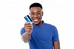 Young Guy Offering Credit Card Stock Photo