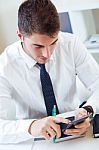 Young Handsome Man Working In His Office With Mobile Phone Stock Photo