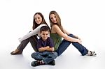 Young Kid Sitting With Teenagers Stock Photo