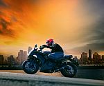 Young Man And Safety Suit Riding Big Motorcycle Against Beautifu Stock Photo