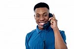 Young Man Attending Phone Call Stock Photo
