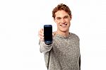 Young Man Displaying Brand New Cellphone Stock Photo