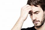 Young Man Holding Head In Hand Stock Photo