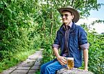 Young Man In A Cowboy Hat And Sunglasses Is Drinking Beer Stock Photo