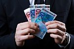 Young Man In Formalwear Holding Money Stock Photo