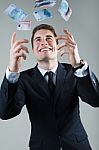 Young Man In Formalwear Throwing Money Stock Photo