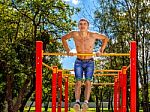 Young Man Is Practicing On A Horizontal Bar Stock Photo