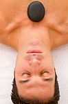 Young Man Receiving Hot Stone Treatment Stock Photo