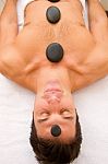 Young Man Receiving Hot Stone Treatment Stock Photo
