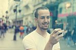 Young Man With Cell Phone Walking Stock Photo