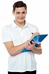Young Man Writing On Clipboard Stock Photo