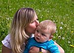Young Mother Kisses Her Little Son Stock Photo