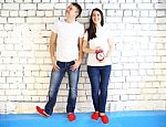 Young Smiling Couple With Red Alarm Clock Stock Photo
