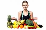 Young Smiling Girl Presenting Fresh Fruits Stock Photo