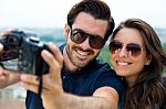 Young Tourist Couple Taking Photo Of Themselves Stock Photo