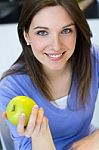 Young Woman Eating Green Apple Stock Photo