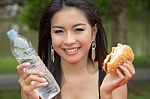 Young Woman Enjoying A Chicken Burger Stock Photo