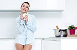 Young Woman Having A Coffee At The Kitchen Stock Photo