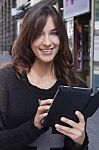 Young Woman Holding A Tablet On The Street Stock Photo
