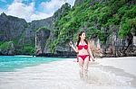 Young Woman In Red Bikini Sitting On The Beach Stock Photo