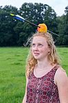 Young Woman Looking Afraid At Arrow In Apple On Head Stock Photo
