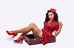 Young Woman Pinup Style Sitting In A Suitcase Stock Photo